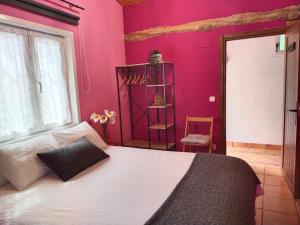 Un dormitorio con una cama grande y una pared rosa en ANTZOMENDI en Mutriku