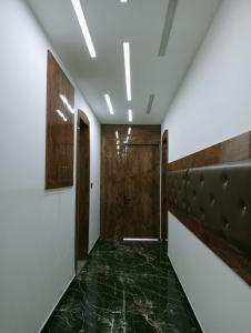 a hallway with a door and a green marble floor at wooden suits in Ghaziabad