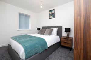 een slaapkamer met een groot bed en een nachtkastje bij Beautiful brand new 3 bedroom city centre house with garden in Derby