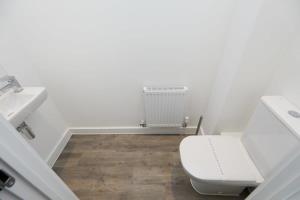 a bathroom with a toilet and a sink at Beautiful brand new 3 bedroom city centre house with garden in Derby +12 photos