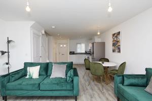 a living room with a green couch and a table at Beautiful brand new 3 bedroom city centre house with garden in Derby