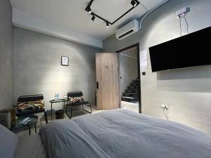a bedroom with a bed and a flat screen tv at hsueh_house in Yilan City