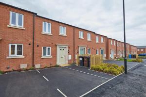 an empty parking lot in front of a brick building at Beautiful brand new 3 bedroom city centre house with garden in Derby