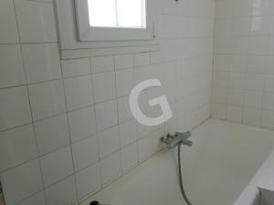 ein weiß gefliestes Bad mit einer Dusche und einem Fenster in der Unterkunft Maison Saint-Vincent-sur-Jard, 3 pièces, 4 personnes - FR-1-357-322 in Saint-Vincent-sur-Jard