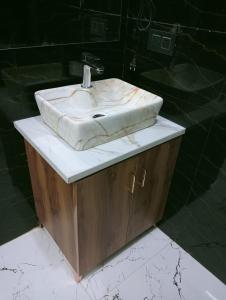 een badkamer met een witte wastafel op een aanrecht bij wooden suits in Ghaziabad