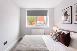 biała sypialnia z łóżkiem i oknem w obiekcie Smart 1 Bed Apartment in the Heart of Eastleigh w mieście Eastleigh
