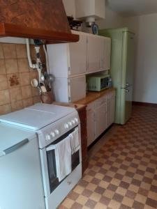 a kitchen with a white stove and a refrigerator at Maison Bienvenue chez Mémé in Treigny