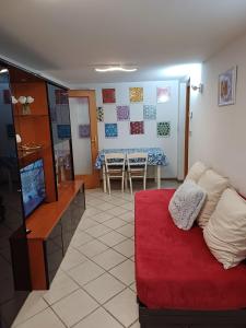 ein Wohnzimmer mit einem roten Sofa und einem Tisch in der Unterkunft Grazioso Appartamento, Aria Condizionata "ALLE MURA DEL CASTELLO 1 Stefano e Paola Marchesini" in Gorizia