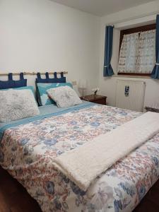 1 dormitorio con 1 cama con colcha de flores en Intero Appartamento "ALLE MURA DEL CASTELLO Stefano e Paola Marchesini", en Gorizia