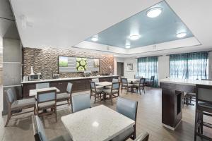 a restaurant with tables and chairs and a bar at La Quinta by Wyndham Houston Hobby Airport in Houston