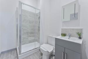 a white bathroom with a shower and a toilet at Contemporary & Cosy 1 Bed Apartment in Dudley in Brierley Hill