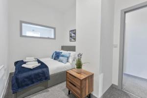 1 dormitorio con cama y mesa de madera en Contemporary & Cosy 1 Bed Apartment in Dudley, en Brierley Hill