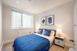 Un dormitorio con una cama azul y una ventana en Cosy 1 Bedroom Apartment in the Heart of Eastleigh, en Eastleigh