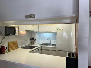 cocina con armarios blancos y encimera blanca en AP21-Sa Riera en Begur