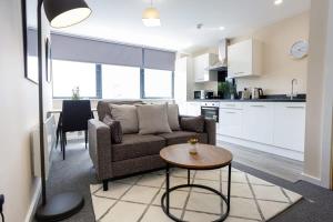 uma sala de estar e cozinha com um sofá e uma mesa em Modern and Stylish 1 Bed Apartment Manchester em Manchester