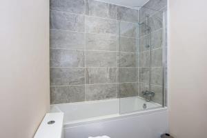 La salle de bains est pourvue d'une douche et d'une baignoire. dans l'établissement Modern 1 Bedroom Apartment, Manchester, à Manchester