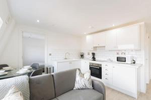 a living room with a couch and a kitchen at Modern 1BR Top Floor Apartment in Ipswich in Ipswich