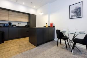a kitchen with a table and a dining room at Contemporary 1 Bed Apartment Central Bolton in Bolton
