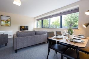 a living room with a table and a couch at Modern 2 Bedroom Apartment Manchester in Manchester