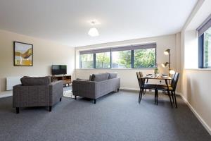 a living room with a couch and a table and chairs at Modern 2 Bedroom Apartment Manchester in Manchester