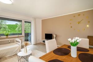 a living room with a table and a clock on the wall at Ferienwohnung Achraintal 3 in Lindau