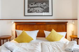 a bedroom with a bed with white sheets and yellow pillows at Baltic Sun W6 in der Villa Sonneck in Ostseebad Sellin