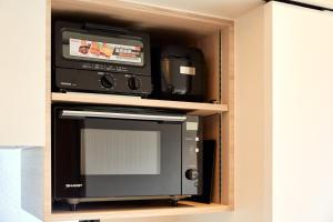 a microwave oven sitting inside of a cabinet at LiveGRACE Mabuji Park Hotel - Vacation STAY 51980v in Tokyo