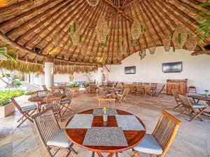 a restaurant with a table and chairs and a wooden ceiling at Vidamar Refugio Costero / Zona Diamante in Acapulco