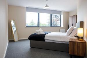 a hotel room with a bed and a large window at Stylish and Bright 2 Bedroom Apartment Manchester in Manchester