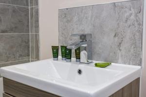 a bathroom sink with a faucet and a shower at Stylish and Bright 2 Bedroom Apartment Manchester in Manchester