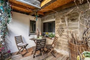 a patio with a table and chairs on a stone wall at Hobbit Lounge in Eppingen