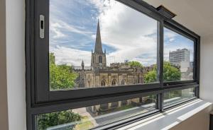 une fenêtre avec vue sur une église dans l'établissement Modern and Bright Studio in Central Sheffield, à Sheffield