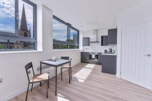 a kitchen with a table and chairs and a view of a church at Modern and Bright Studio in Central Sheffield in Sheffield