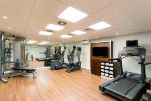 a gym with several treadmills and machines in a room at Courtyard by Marriott Edinburgh in Edinburgh