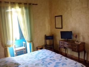 a bedroom with a bed and a desk with a television at Hotel Rural 4 Esquinas in San Miguel de Abona