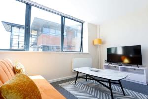 uma sala de estar com uma mesa e uma televisão em Fantastic 1 Bedroom Apartment Manchester em Manchester