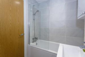 uma casa de banho com um chuveiro, uma banheira e um lavatório. em Fantastic 1 Bedroom Apartment Manchester em Manchester