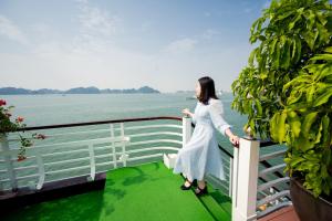 a woman in a white dress standing on a railing at Dragon Crown Legend Cruise in Ha Long