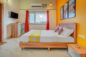 ブバネーシュワルにあるHotel O Cosmopolis Bhubaneswar Formerly Luxury Stayのベッドルーム1室(オレンジ色の壁の大型ベッド1台付) +42枚の写真