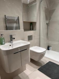 een badkamer met een wastafel, een toilet en een douche bij Gallery Apartments in Londen