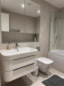 a white bathroom with a sink and a toilet at Gallery Apartments in London