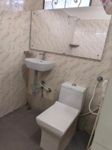 uma casa de banho com um WC branco e um lavatório. em CM Residency em Salem