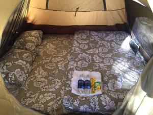 uma cama numa tenda com duas garrafas em Dalat Inn ez home em Da Lat