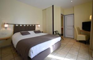 a bedroom with a large bed and a chair at Le Relais du Vivarais in Viviers