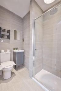 a bathroom with a shower and a toilet and a sink at Lovely Studio Apartment in Central Sheffield in Sheffield