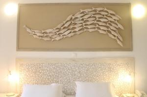 a painting above a bed with white pillows at Ambelas Mare Apartments in Ambelas