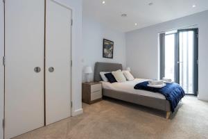 ein Schlafzimmer mit einem Bett und einem großen Fenster in der Unterkunft Stunning 2 Bedroom Apartment Manchester in Manchester
