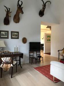 a living room with a table and antlers on the wall at Cozy, quiet guest house perfect for business or pleasure in Hillerød