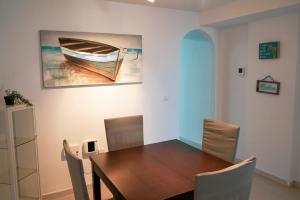 a dining room with a table and a painting of a boat at Casa Lince: 2/2 in Marbella in Marbella
