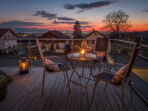 a patio with a table and chairs on a deck at 2 in holiday home Sandra in Hörbranz